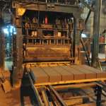 Concrete bricks manufactured from recycled rubble roll off the production line at Cape Brick in Salt River, Cape Town.