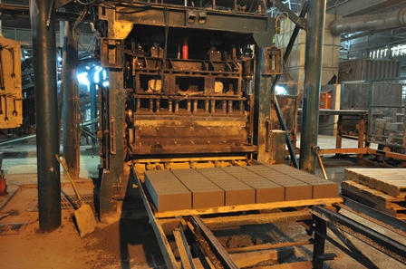 Concrete bricks manufactured from recycled rubble roll off the production line at Cape Brick in Salt River, Cape Town.