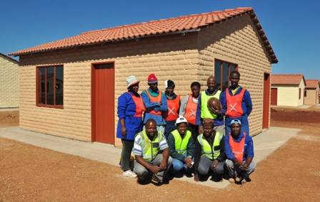 A group of workers pose proudly outside one of the completed houses at Ga-Rankuwa Extension 24.