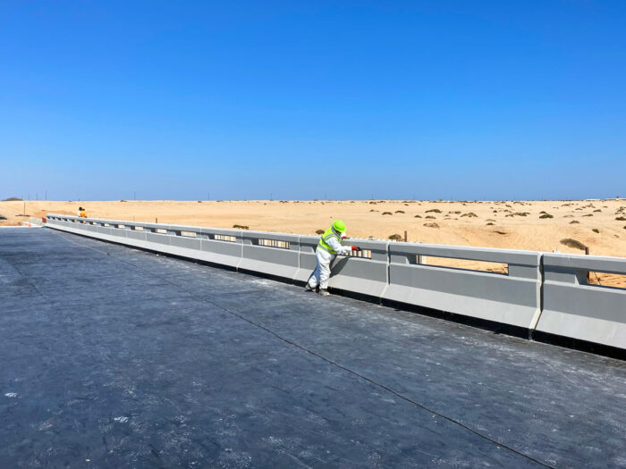 worker touching up concrete bridge